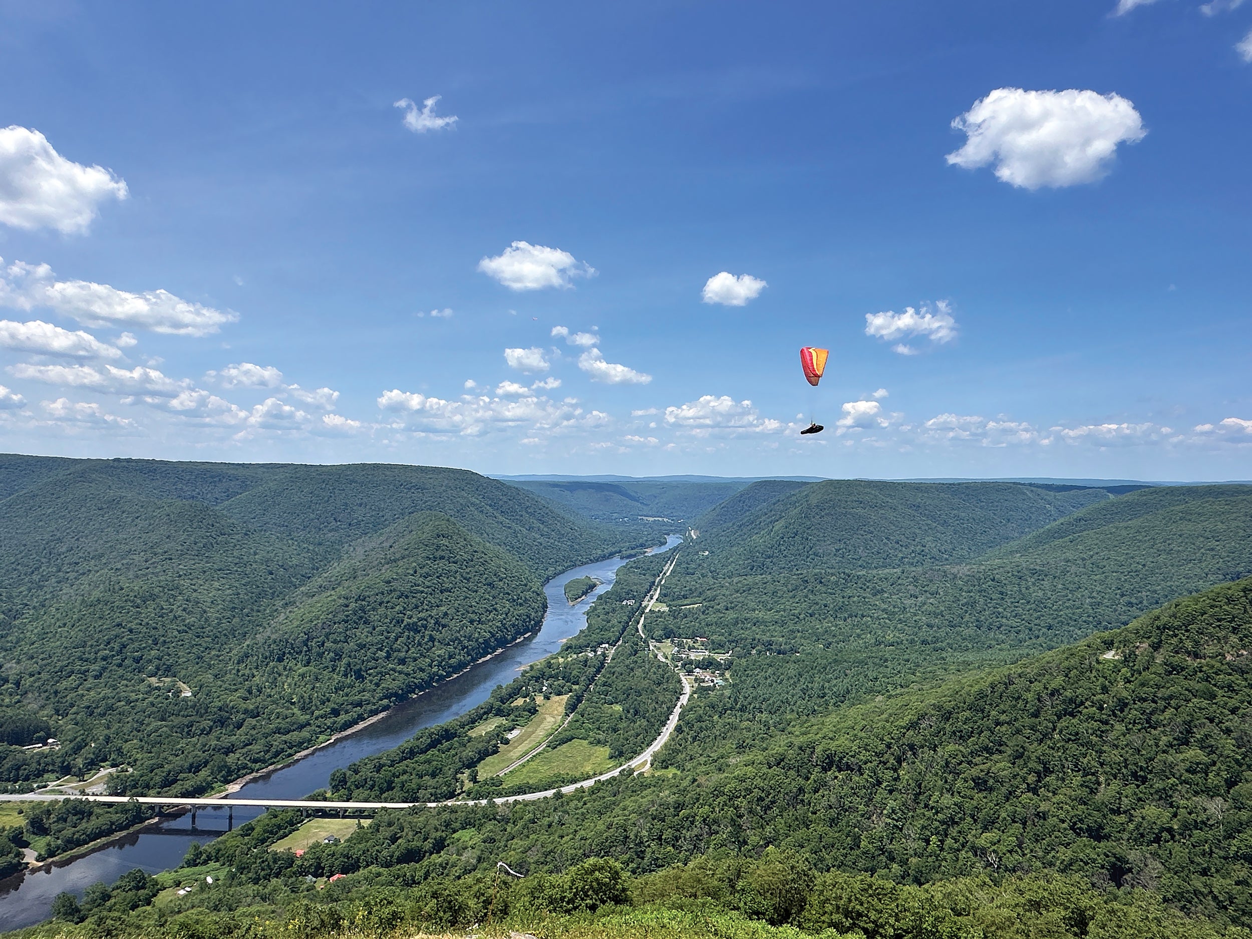 A paraglider soars above the Susquehanna River after launching from a platform at the overlook at Hyner View State Park in Clinton County.