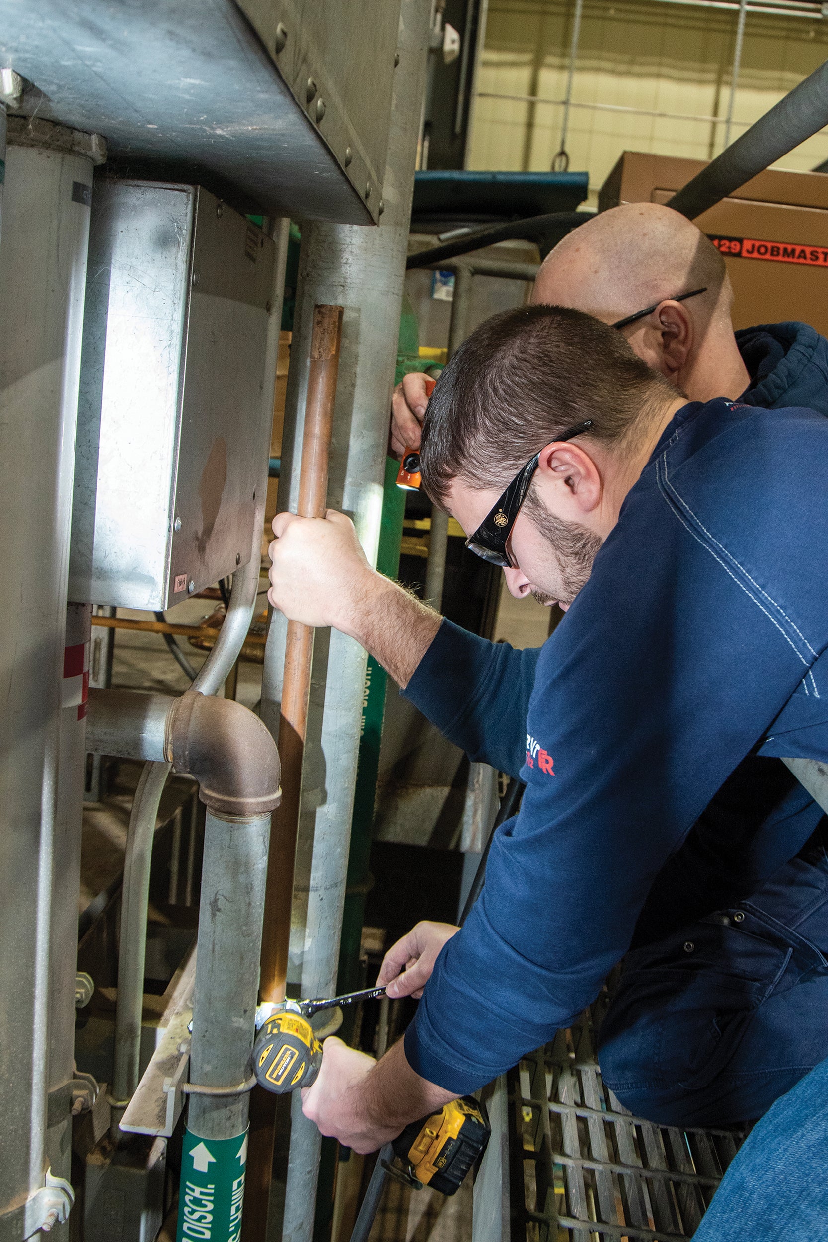 Charles Hackenberry and Victor Jackson secure piping to reroute water during maintenance at the plant.